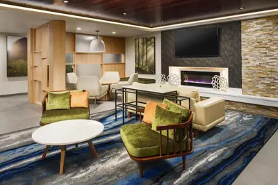 a lobby with chairs and a table and a fireplace at Fairfield Inn & Suites by Marriott Oakhurst Yosemite in Oakhurst