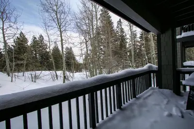a balcony with snow on the railing of a house at Mammoth Green #102 condo in Mammoth Lakes