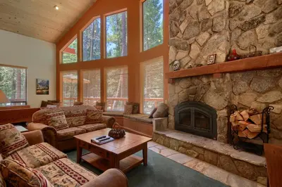 a large living room with a stone fireplace at 92R Jolie Cabin in North Wawona