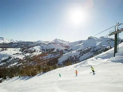 three people skiing down a snow covered ski slope at CREEKSIDE LODGE in Markleeville
