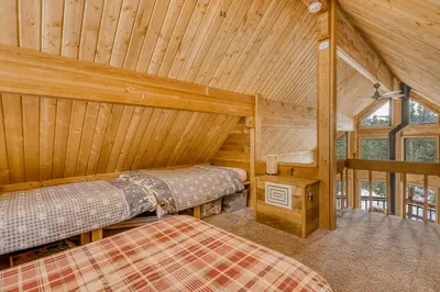 a bedroom with two beds in a wooden cabin at Soda Springs Surprise in Soda Springs