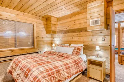 a log cabin bedroom with a bed and a window at Soda Springs Surprise in Soda Springs