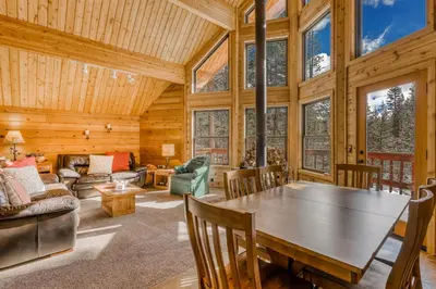 a log cabin living room with a table and chairs at Soda Springs Surprise in Soda Springs