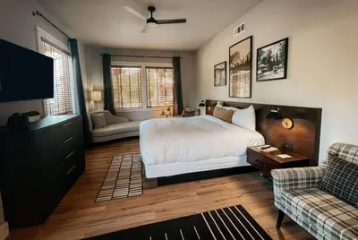 a bedroom with a bed and a couch and a tv at Gateway Hotel, Trademark Collection by Wyndham in Copper Cove Subdivision
