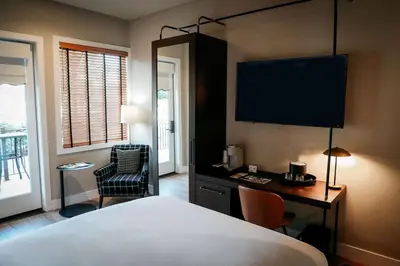 a hotel room with a bed and a desk with a television at Gateway Hotel, Trademark Collection by Wyndham in Copper Cove Subdivision