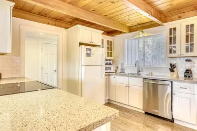 a kitchen with white appliances and a wooden ceiling at Flicker Retreat in Homewood