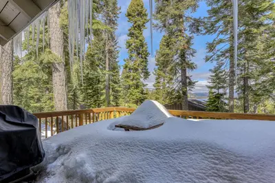 a bed on a deck with snow on it at Flicker Retreat in Homewood