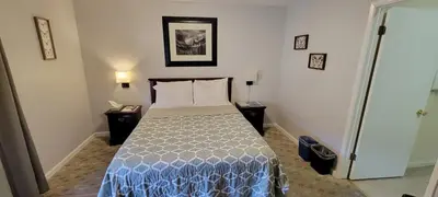a small bedroom with a bed and two night stands at 5th Street Inn in Mariposa
