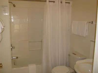 a white bathroom with a shower and a toilet at 5th Street Inn in Mariposa