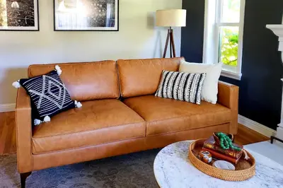 a brown leather couch in a living room at Ski, Shop and Explore Walkable Midtown Reno Oasis! in Reno