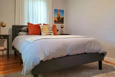 a bedroom with a bed with orange and blue pillows at Ski, Shop and Explore Walkable Midtown Reno Oasis! in Reno