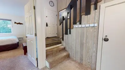 a hallway with stairs leading to a room with a bed at 2 Bedroom Condos at Mammoth Estates - Near Mammoth Village! in Mammoth Lakes
