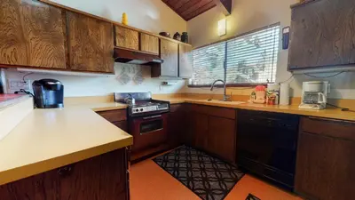 a kitchen with wooden cabinets and a stove top oven at Mammoth Estates Deluxe 2 Bedroom Condos in Mammoth Lakes