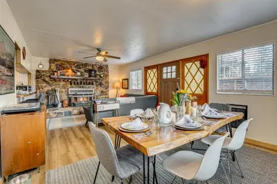 a kitchen and dining room with a wooden table and chairs at Balcony and Forest Views Cabin in Pioneer! in Pioneer
