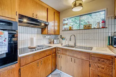 a kitchen with wooden cabinets and a sink and a window at Balcony and Forest Views Cabin in Pioneer! in Pioneer