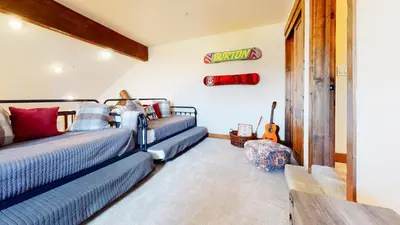 a bedroom with two beds and a guitar on the wall at Snowcreek The Lodges #1127 condo in Mammoth Lakes