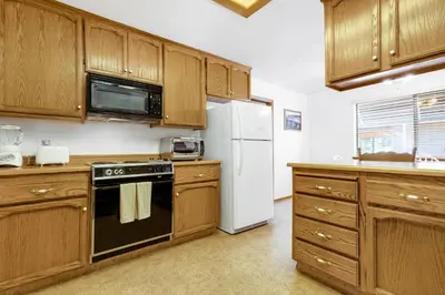 a kitchen with wooden cabinets and a white refrigerator at Mountain Springs Lodge in Groveland