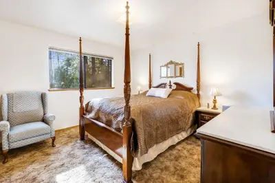 a bedroom with a bed and a chair at Mountain Springs Lodge in Groveland