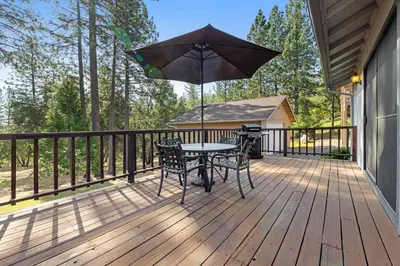 a patio with a table and chairs and an umbrella at Mountain Springs Lodge in Groveland