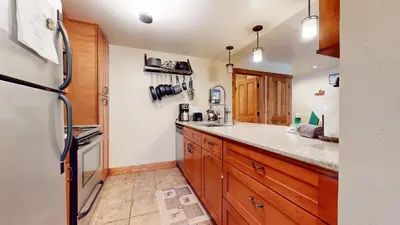 a kitchen with wooden cabinets and a refrigerator at Snowcreek #13 condo in Mammoth Lakes