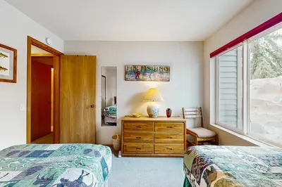 a bedroom with two beds and a dresser and a window at Snowcreek 607 in Mammoth Lakes