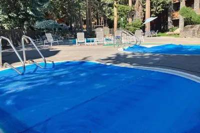 an empty pool with blue water in a park at Summit 70 in Mammoth Lakes