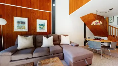 a living room with a brown couch and a table at Summit #293 condo in Mammoth Lakes