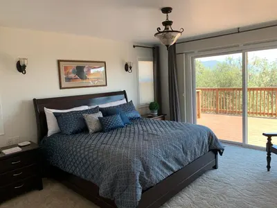 a bedroom with a bed and a balcony at Villa Alta Vista at Yosemite- Stunning Views and Game Room in Mariposa
