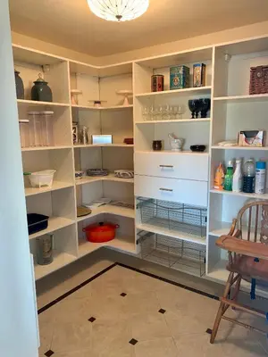 a walk in pantry with white shelves and a chair at Villa Alta Vista at Yosemite- Stunning Views and Game Room in Mariposa