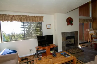 a living room with a tv and a fireplace at Mammoth Ski Racquet Club 55 in Mammoth Lakes