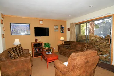 a living room with couches and a flat screen tv at Sierra Park Villas 29 in Mammoth Lakes