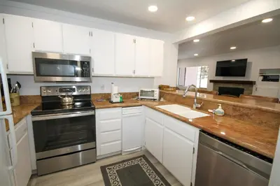 a kitchen with white cabinets and stainless steel appliances at Mammoth Ski Racquet Club 127 in Mammoth Lakes