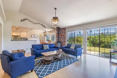 a living room with blue chairs and a table at Spectacular Views w/ Hot Tub/BBQ -Yosemite & Bass Lake in Oakhurst