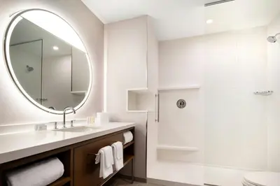 a white bathroom with a sink and a mirror at Courtyard by Marriott Fresno Clovis in Clovis