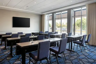 a conference room with tables and chairs and a flat screen tv at Courtyard by Marriott Fresno Clovis in Clovis