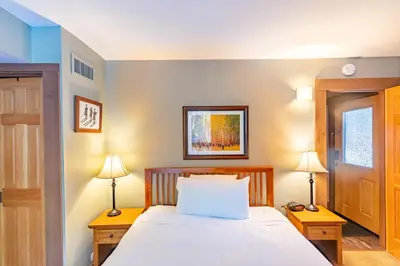 a bedroom with a bed with two night stands and two lamps at Cozy Aspen Grove 2 bed 2 bath condo in Truckee