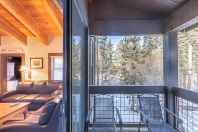 a living room with a couch and a large window at Cozy Aspen Grove 2 bed 2 bath condo in Truckee