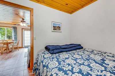 a bedroom with a bed with a blue pillow on it at Yosemite Mountain Cottage in Groveland