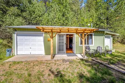 a green tiny house with a white garage at Yosemite Mountain Cottage in Groveland