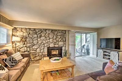 a living room with a stone wall at Hot Tub Access Mammoth Lakes Nature Escape! in Mammoth Lakes