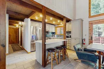 a kitchen with a bar and stools in a house at Seclusion in Style in Truckee