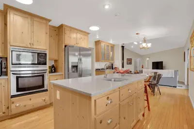 a kitchen with wooden cabinets and stainless steel appliances at Moonrise Lodge - A Large Vacation Home in Mariposa in Mariposa