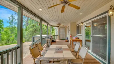 a screened porch with a table and chairs and a ceiling fan at Moonrise Lodge - A Large Vacation Home in Mariposa in Mariposa