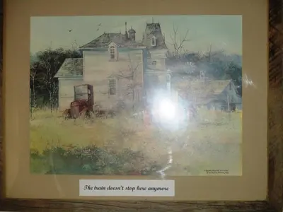 a painting of an old house in a frame at Virginia City Inn in Virginia City