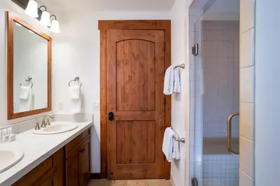 a bathroom with two sinks and a wooden door at Annie's Loop, Gray's Crossing 10215 in Truckee