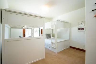 a bedroom with white bunk beds and a window at Annie's Loop, Gray's Crossing 10215 in Truckee