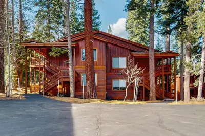 a large wooden cabin in the middle of trees at Truckee Treat in Truckee