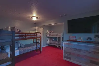 a room with two bunk beds and a flat screen tv at Cozy mountain retreat with lake views near Yosemite in Groveland
