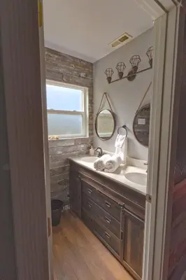 a bathroom with a sink and two mirrors at Cozy mountain retreat with lake views near Yosemite in Groveland