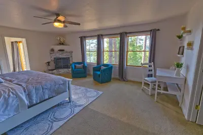 a bedroom with a bed and a desk and windows at Cozy mountain retreat with lake views near Yosemite in Groveland